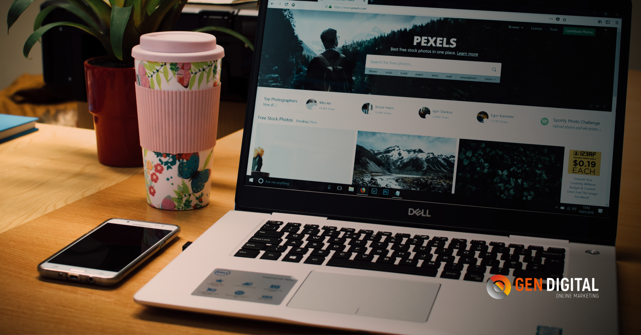 Laptop mostrando una página web mientras un smartphone y café acompañan el trabajo de optimización digital desde redes sociales.